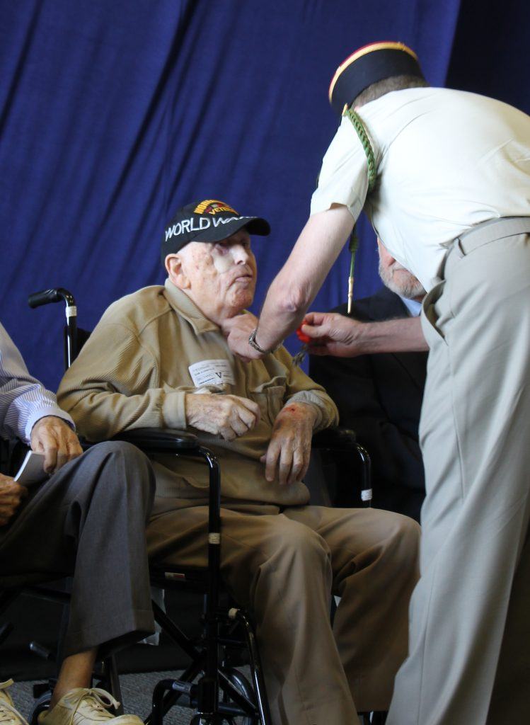 Sam Kornfeld, Vétéran d'Omaha Beach et de la Seconde Guerre Mondiale, recevant les insignes de Chevalier dans l'ordre de la Légion d'Honneur, des mains du capitaine Jean-Michel Caffin.