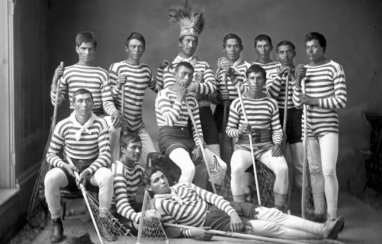 Photo: William Notman / Musée McCord Équipe de crosse de Kahnawake, en 1876. La majorité de ces joueurs avaient voyagé en Angleterre pour une tournée organisée par William George Beers. L’homme portant une coiffe traditionnelle est le capitaine de l’équipe, Sawatis Aiontonnis.