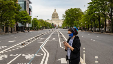 Une jeune femme masquée passant devant le capitole des Etats-Unis, à Washington DC.