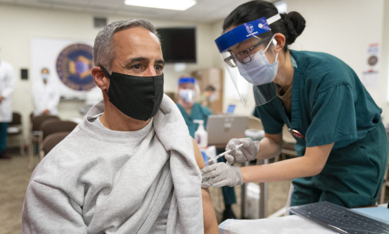 Etats-Unis - Qui pourra se faire vacciner (et quand) contre la covid-19 : nos réponses. Photo : Senior Enlisted Advisor to the Chairman (SEAC) Ramon "CZ" Colon-Lopez receives a COVID-19 vaccine at Walter Reed National Military Medical Center, Bethesda, Md., Dec. 21, 2020.