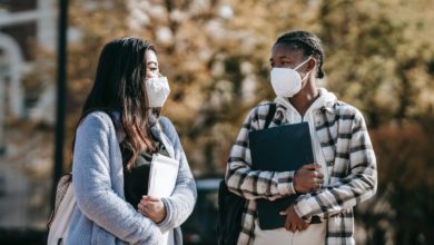 diverse students with laptop and documents