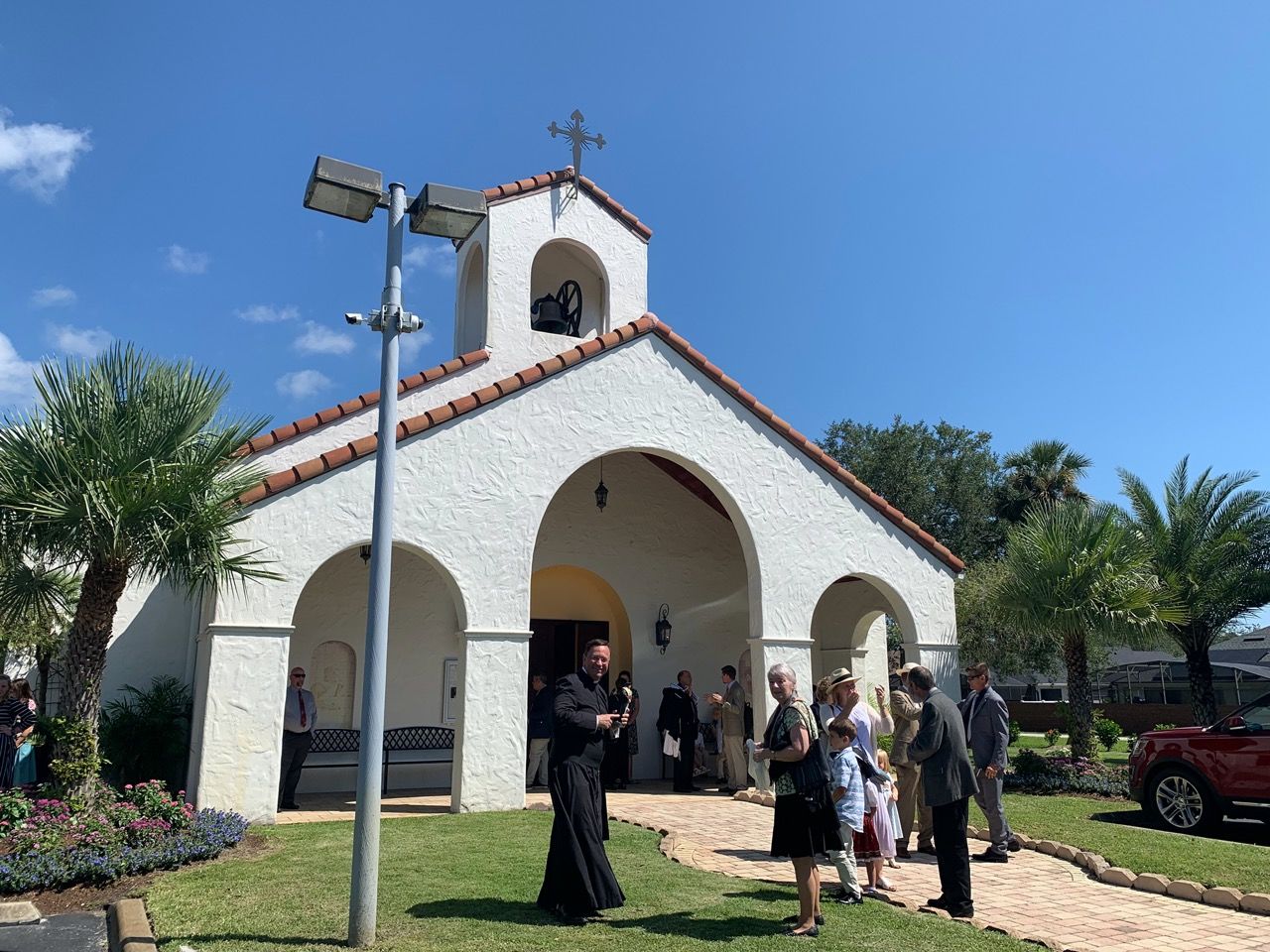 L'abbé Marc Vernoy devant son église de Sanford.
