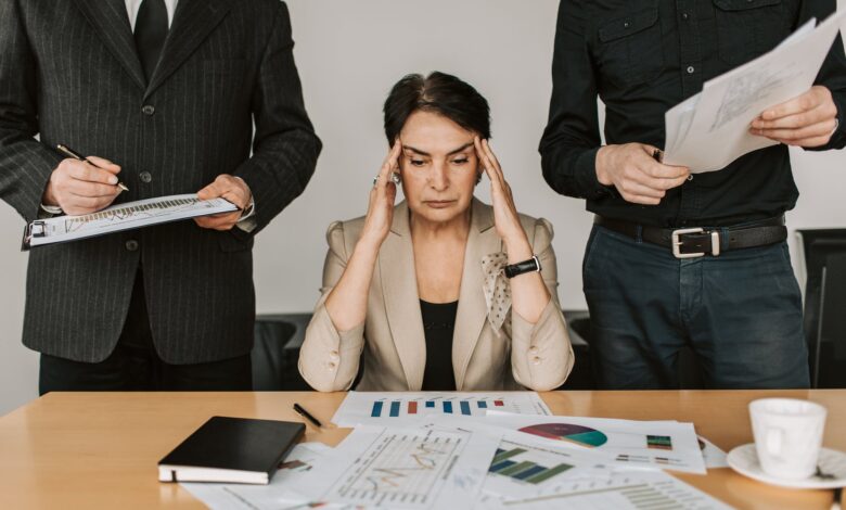 stressed elderly woman holding her head
