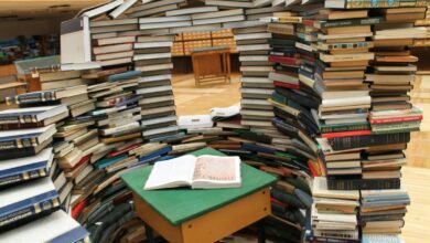 a room filled with lots of books on top of a wooden floor
