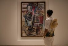 A man looking at a painting in a museum